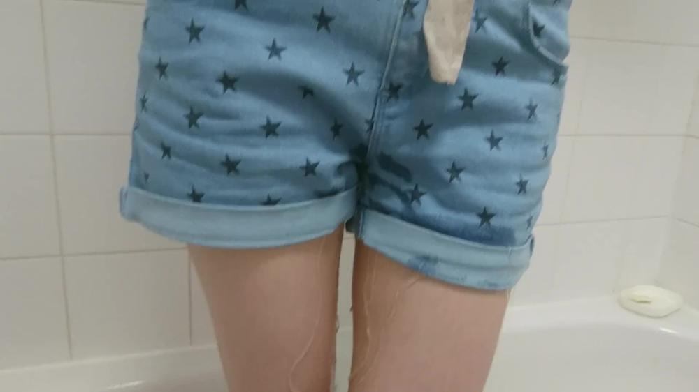 girl wets her denim shorts